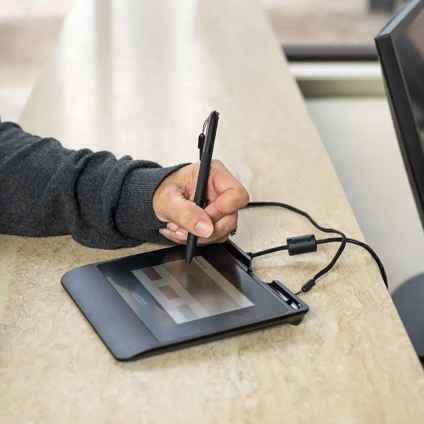 Una persona firma con la penna su un pad di firma